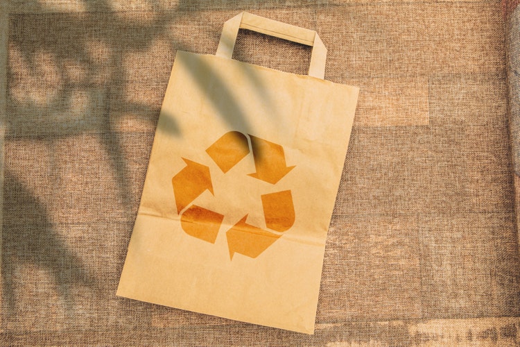 Paper grocery bag displaying recycling icon