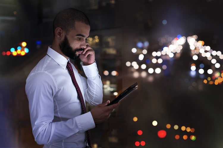 Photo of a businessman talking on his cellphone late at night.