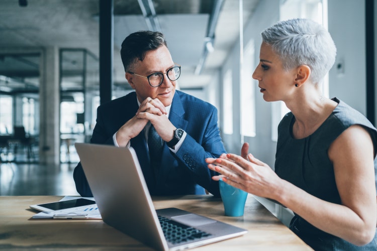 Female and male finance professionals in discussion at a table
