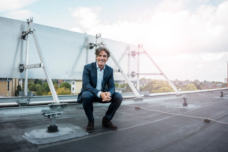 Smiling man sitting on rooftop