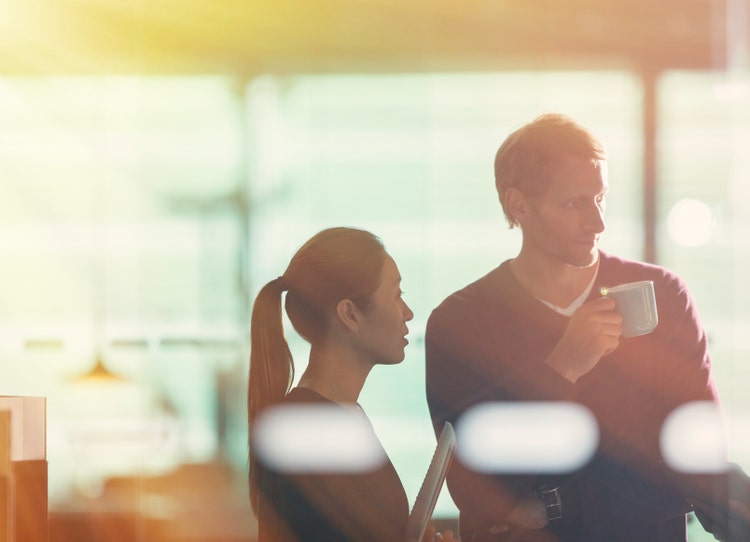Close up of two employees speaking privately
