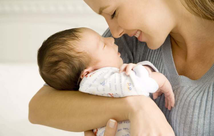 A smiling mother caring for a newborn child