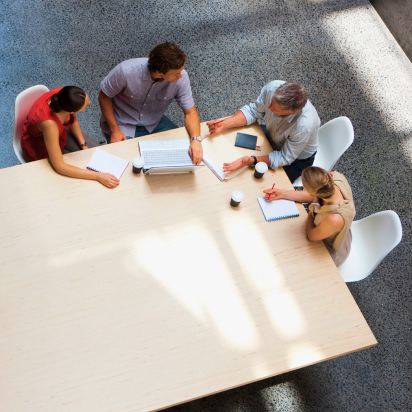 Coworkers using digital devices in office - stock photo