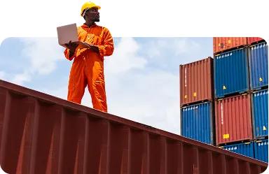 Black worker using a laptop working in the commercial dock - stock photo