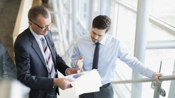 Men walking upstairs in office while discussing business