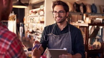 Sales assistant with credit card reader on digital tablet