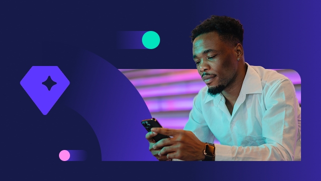 Young man using a smartphone on neon-lit stairs