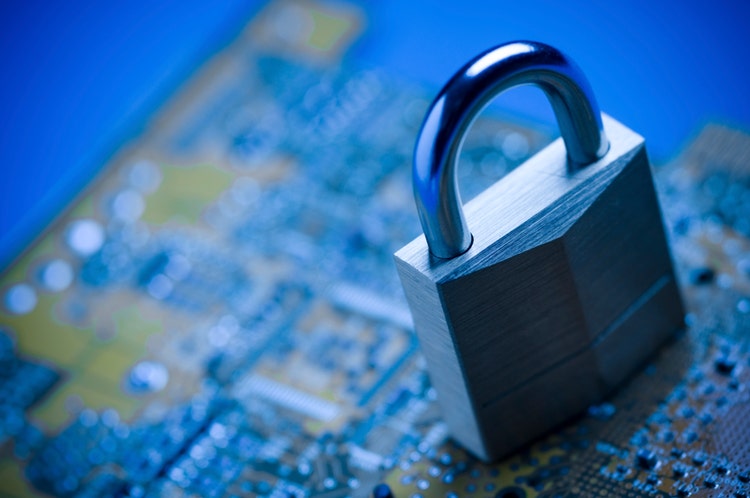 A closed lock resting on top of a computer chip