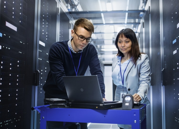 IT Technicians Working on business AI with Computer Crash Cart in Data Center Rack Servers